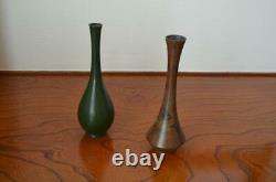 Furthermore A set of two bronze vases with a single flower