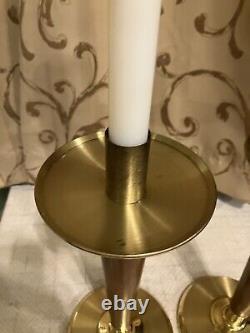 Ensemble de deux chandeliers d'autel lourds en laiton et bois pour lampe à huile pascale.